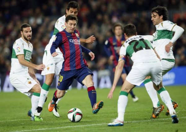 Barcelona's Lionel Messi challenges for the ball against Elche's Edu Albacar and other players during their Spanish King's Cup soccer match at Camp Nou stadium in Barcelona