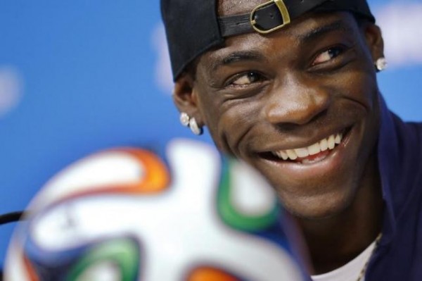 Italy's national soccer team player Mario Balotelli smiles while answering a question during an news conference at the Pernambuco arena in Recife